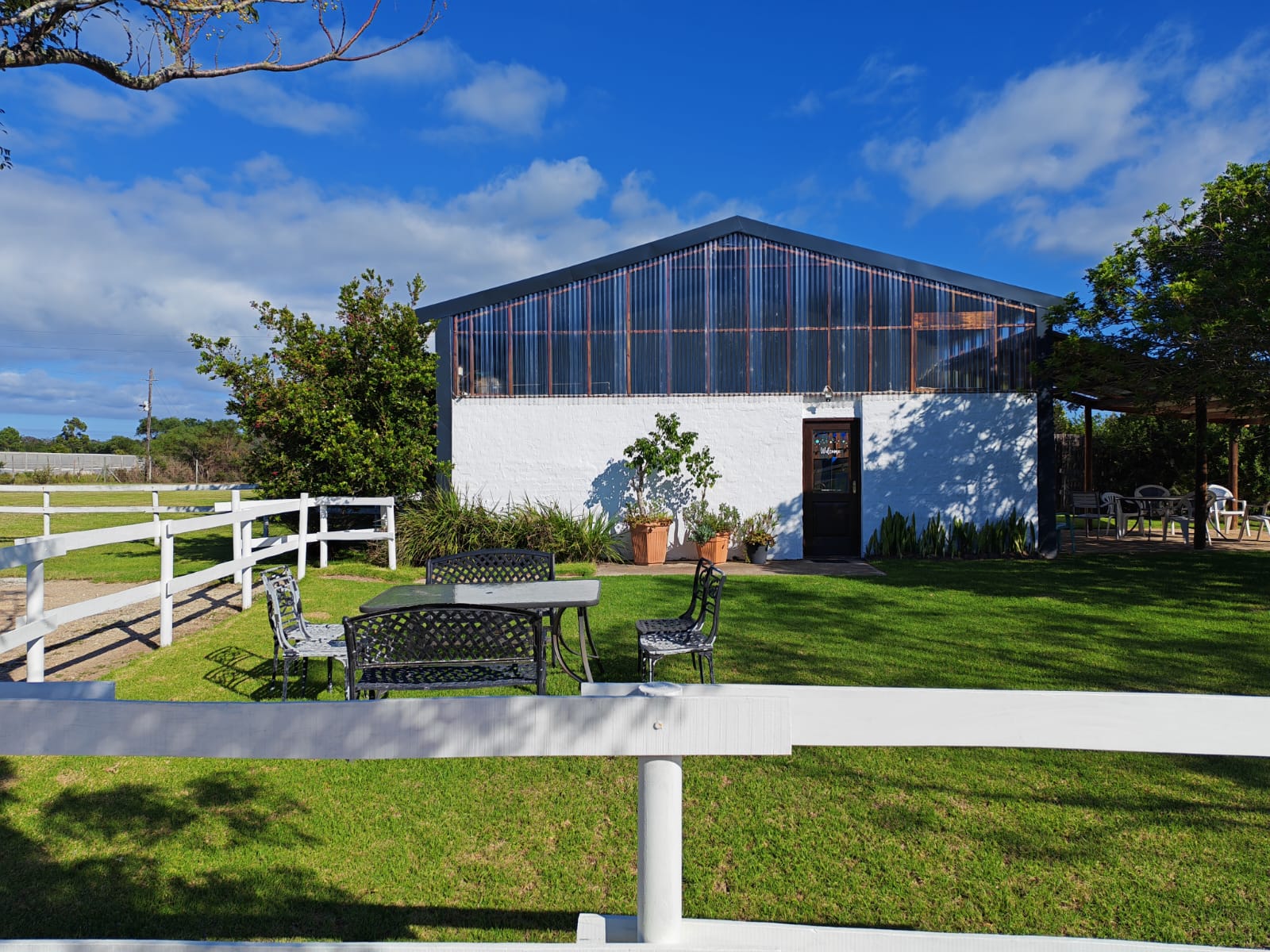 Exterior view of the Plettenberg Bay Swim Centre pool building with garden seating